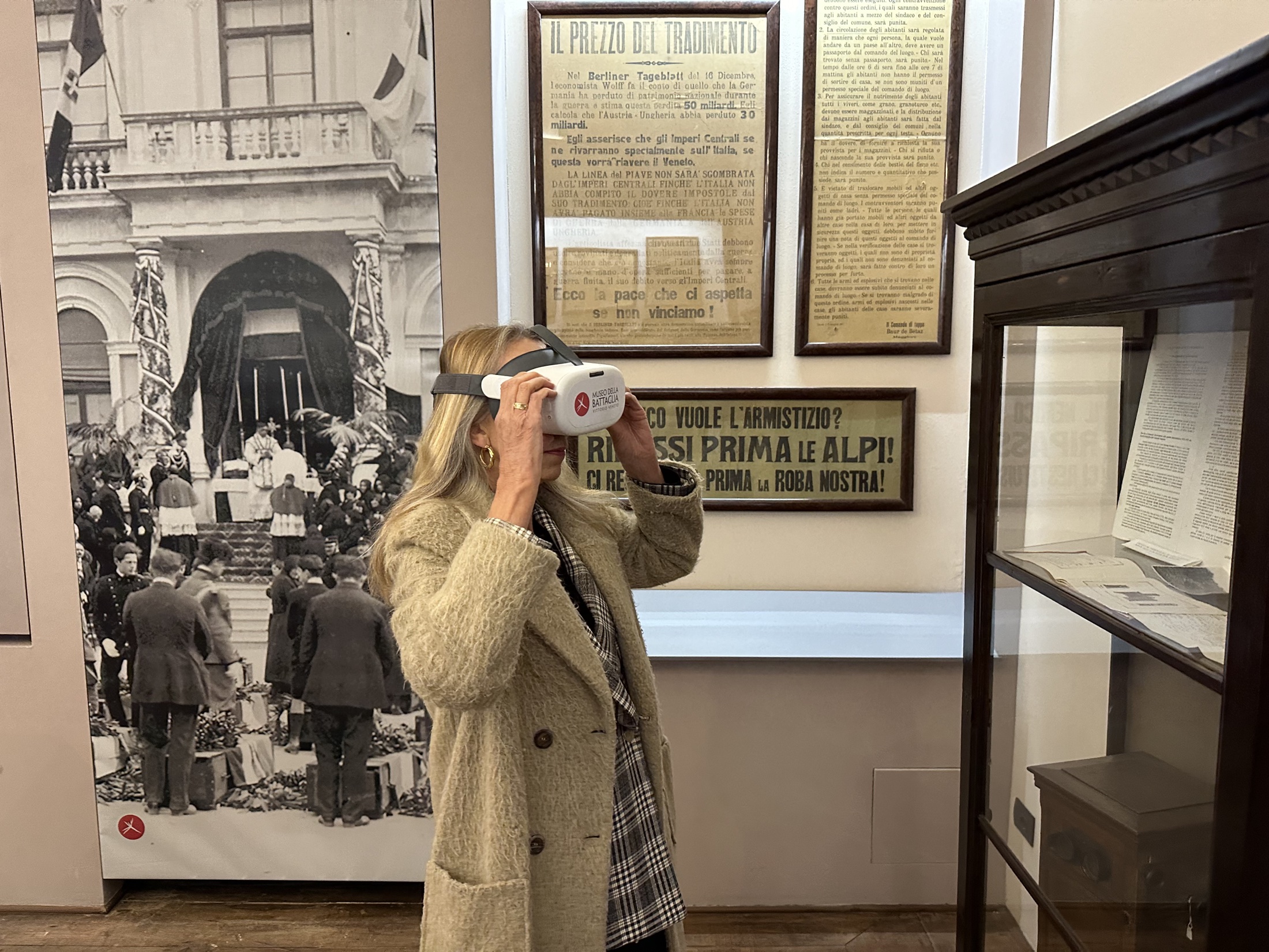 Visitatrice con visore VR davanti ai pannelli storici